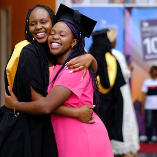 Two graduates hugging