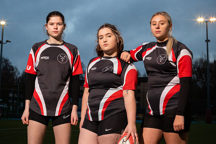 Three rugby players standing together.