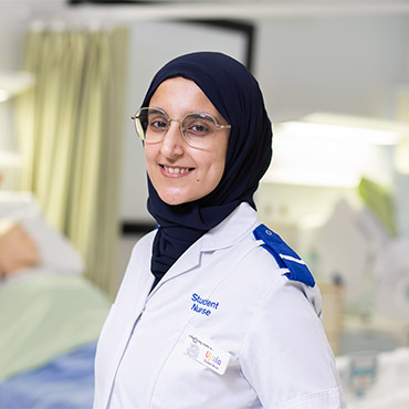 A student nurse smiling at the camera