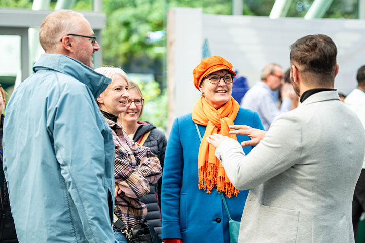 A professor chatting to a group of people.