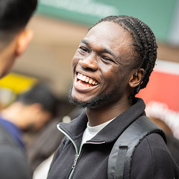 Two students looking at a phone and laughing.