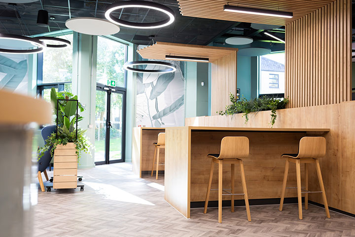 An empty well lit seating area decorated with wood and indoor plants