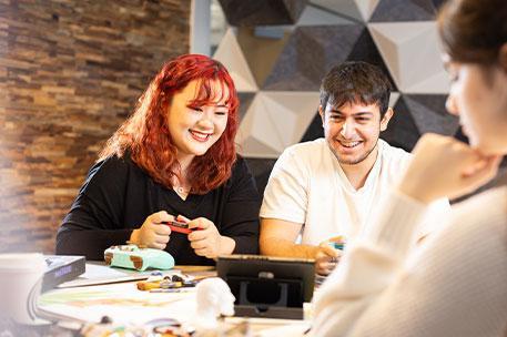 Two students playing on a gaming console.