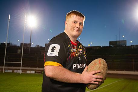 A student holding a rugby ball.