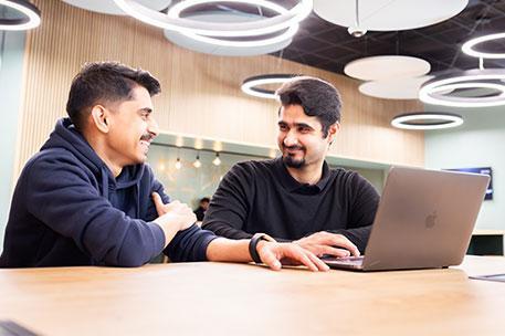 Two students watching a laptop.