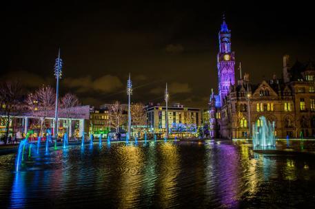 Bradford City Hall and Centenary Square at night with multicoloured lights and fountains