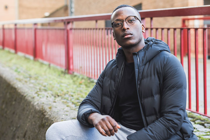 A student sitting on steps and looking at the camera