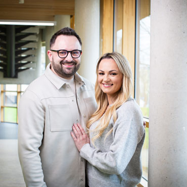 Two students standing together and smiling at the camera