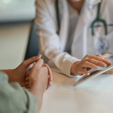 A medical student showing a tablet device to a patient