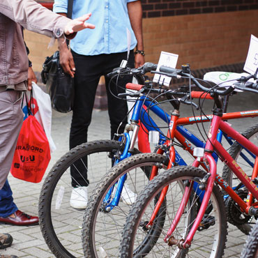 Two people standing near a row of bicycles