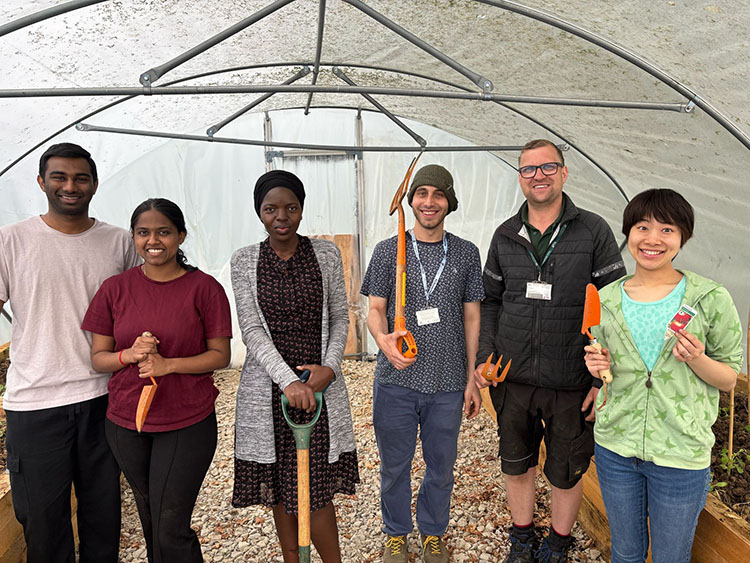 Students posing before planting vegetables in poly tunnel