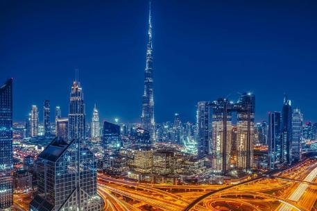 Dubai skyline illuminated at night, showcasing skyscrapers against a dark sky.
