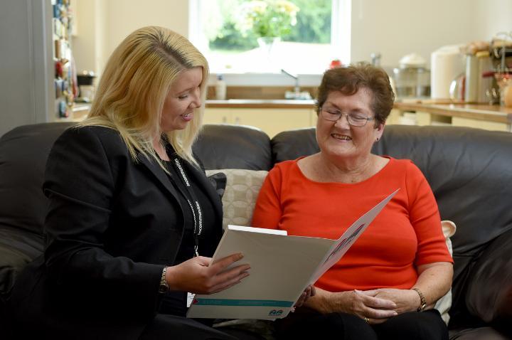 Woman showing another woman paperwork in a folder