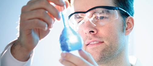 Scientist looking at piece of lab equipment which is shining