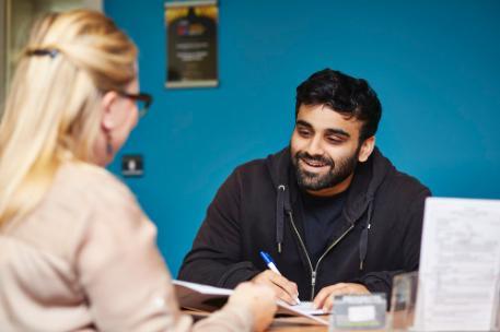 A student receptionist at careers talking to a customer