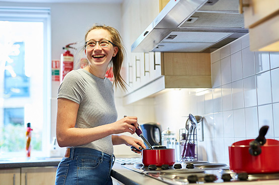 A student cooking food in their student accommodation.