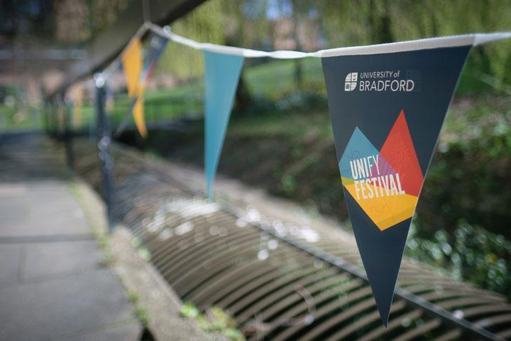 Bunting with the University of Bradford and UNIfy Festival logo along a railing