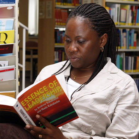 A student reading a book on leadership and management.