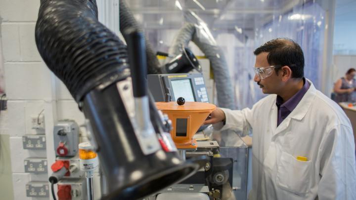 Researcher using injection moulding equipment