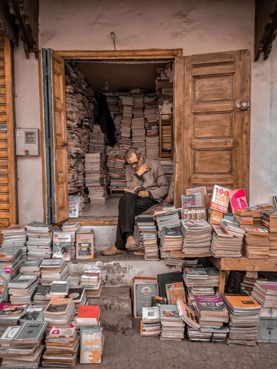 Photo of man reading amongst stacks of books, featured on Leverhulme Trust Newsletter Cover