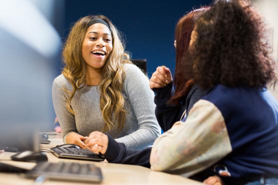 Happy Psychology student sitting at a computer.