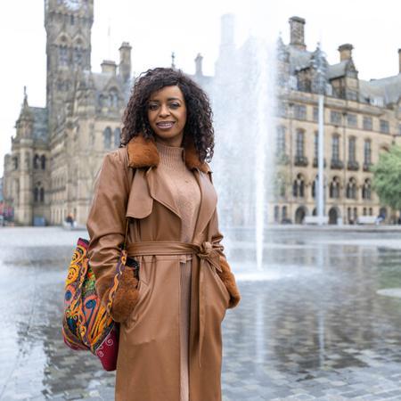 Student posing in front of Bradford City Hall.