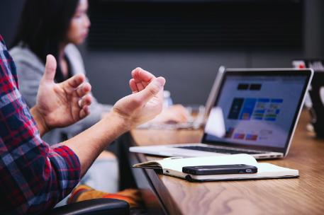 Close up photo on a meeting participant's hands as they speak from notes - photo by Headway.io on Unsplash