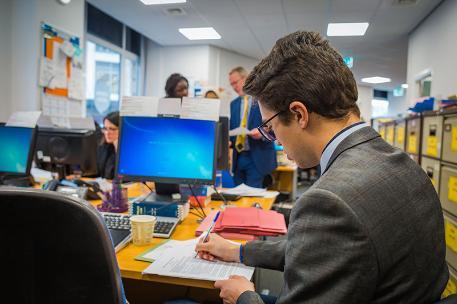 A background shot of a student wearing a suit.