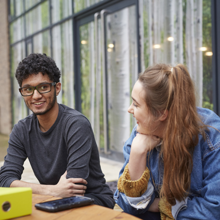 Two students sat outside The Orchard chatting