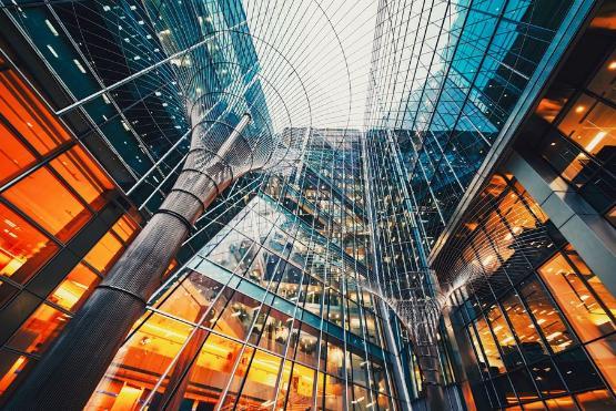 glass buildings reflecting light in blues and soft glowing orange