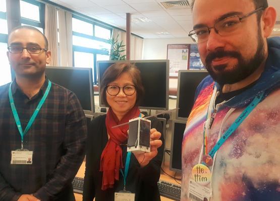 Academics holding the pocket cube satellite prototype