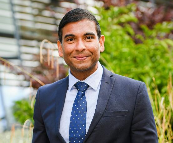 Staff member smiling to camera in suit and tie