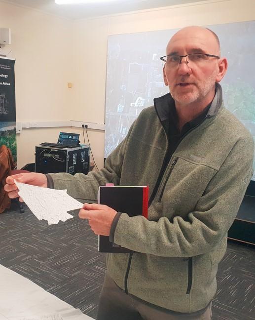 Professor Chris Gaffney holding a scale model of part of Bradford