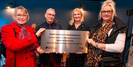 A group of people holding a commemorative plaque