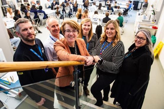 group of people stood up in university workshop room