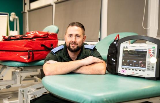 Student sat down with arms folded in front of them next to medical equipment