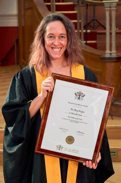 PhD Amy Hughes holding her award