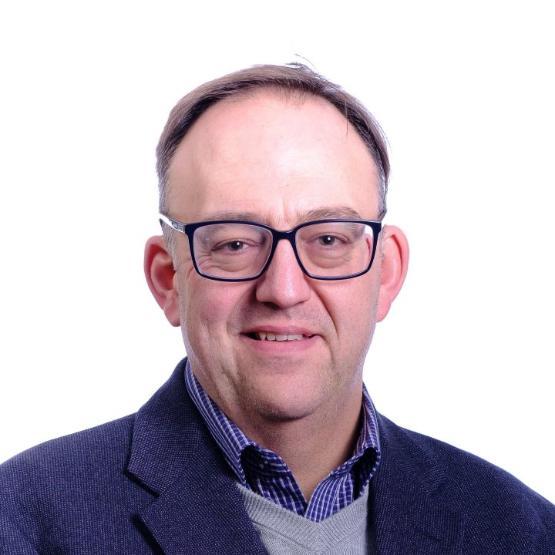 A head and shoulders photo of a University staff member who is wearing glasses