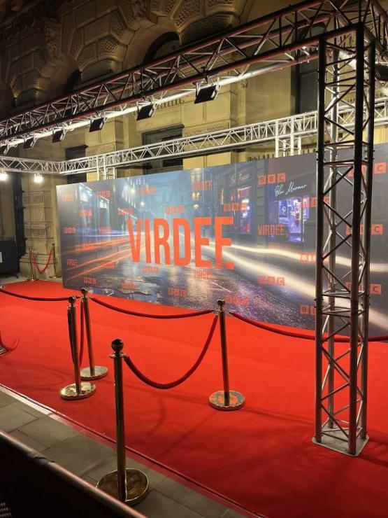 A roped off VIP area with a red carpet outside an entertainment venue