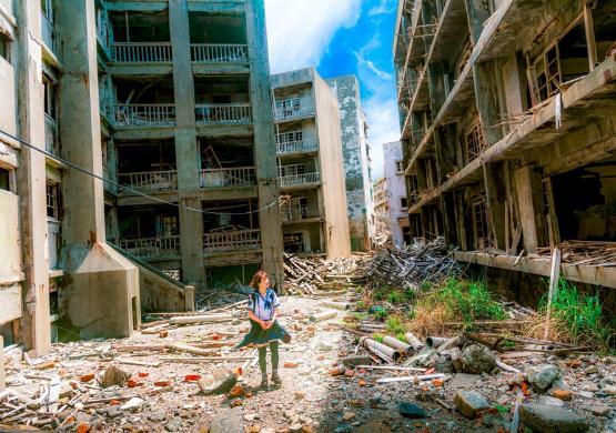 A child standing amid the rubble of some bombed damaged buildings