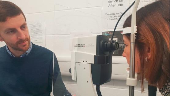 Dr Jonathan Denniss examining a patient in an ophthalmology room