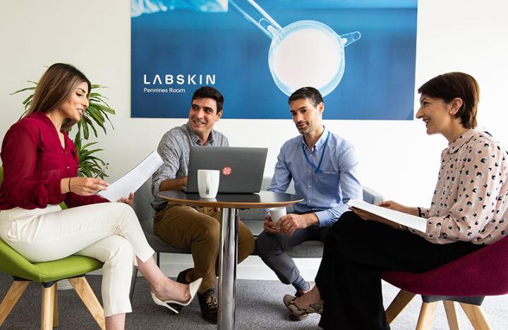 Team members on the LabSkin KTP having a discussion around a table, including Dr Sobia Kauser and Dr Jacobo Elies Gomez from University of Bradford