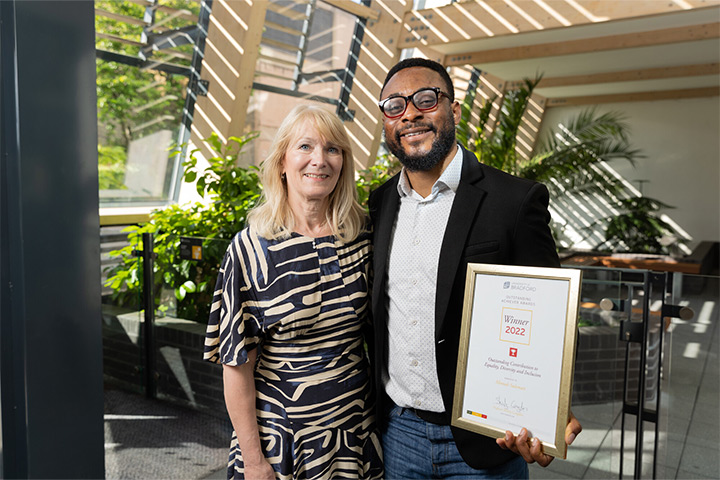 A student and the Vice Chancellor face the camera posing with the 'winners' certificate