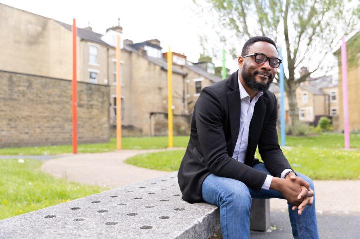 A student sitting in an urban park on a concrete bench