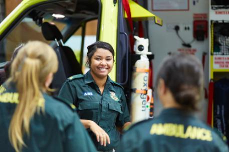 Paramedic Science students by an ambulance