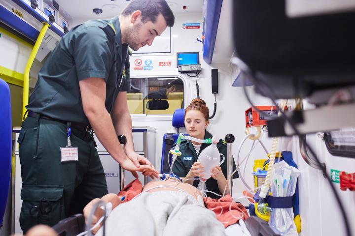 Paramedic Science students working in the back of an ambulance.