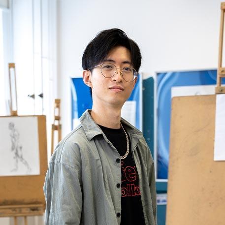 A student looking at the camera in the drawing room.