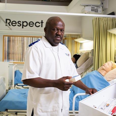 A student nurse smiling at the camera.