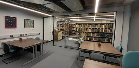 Special Collections Reading room containing desks, chairs, shelves of books and other reading materials.