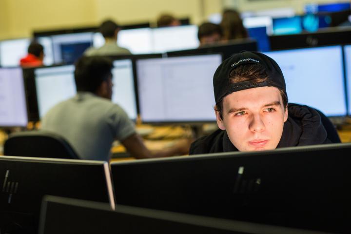 A computer science student sat behind a computer.